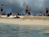 Large plane takes off beside tourist beach...