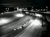 Car slides and falls from a bridge next to a highway.