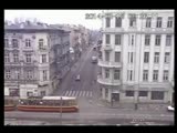 Two oblivious men crossing the road are crushed by a tram.