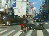 SUV Sends Biker Under The Wheels Of An Oncoming Car