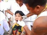 Strange rituel - guy gets pierced in the cheeks with a huge metal sting.