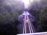 Train runs over women crossing railroad bridge.