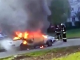 Firefighters Standing Too Close To A Burning Car With A Gas Cylinder Inside