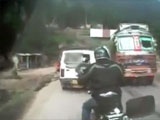 Top Heavy Truck Takes A Corner Too Fast And Lands On A Waiting Biker