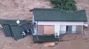 Woman Gets Swept Away From A Man By Flood Water As They Desperatley Cling To A Cable Between Two Floating Houses