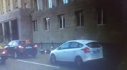biker falls by himself and starts to kick the car