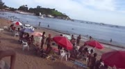couple having sex in the sea near beach full of people