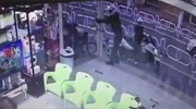 Assassin On A Scooter Shoot A Man From Behind Sitting Having A Drink