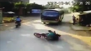 Couple On A Motorcycle Slide Straight Under The Wheels Of An Oncoming Bus