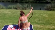 Girl in a Bikini Catches a Cobra While Sunbathing