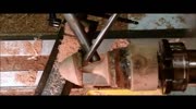 Guy turning wooden piece in lathe gets it to face