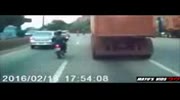 Motorcylist hits a pedestrian, falls & end up under a huge truck!