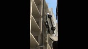 Drivers car hanging midair over parking garage.