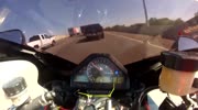 Lane-splitting motorcyclist in traffic with shorts.