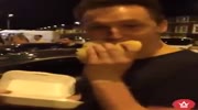 Dude enjoys his food watching street brawl