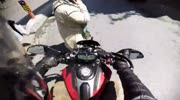 Woman with cell phone is pushed by motorcycle