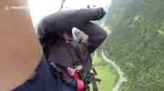 creaming paraglider plunges to earth desperately struggling with his tangled parachute then crashes through trees and hits the ground