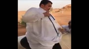 A fat Arab trying to get on a horse ..