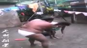 Topless African Land Whale Disciplines Its Offspring with Broad Side of Machete