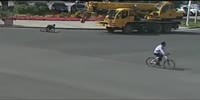 Girl on a cycle is knocked by a crane
