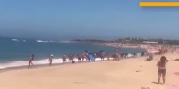 Holidaymakers watch stunned as dozens of migrants storm Spanish beach