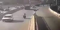 Two bikers collide, causing both to slam into the center medium.