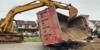 A fully loaded red dump truck crushed a biker flat