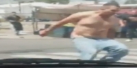 Shirtless man uses a screwdriver in argue