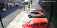 Motorcycle clips a car bumper at speed.