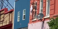 Crazy nude woman hold onto ledge with her fingers