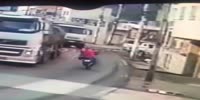 Biker slides under dump truck and gets ran over