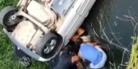 Woman rescued after overturning car in stream