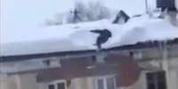 Man Cleaning The Snow Falls Off The Roof In Russia