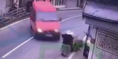Elderly woman walking in the street get pinned by red van