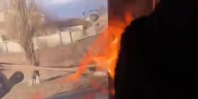 Ukrainians attacking a Russian military vehicle with a Molotov cocktail.