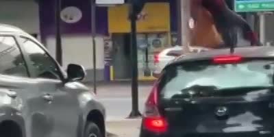 Spiderman asking for coins at a traffic light