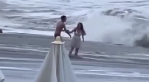 Woman gets swept out to sea as her boyfriend frantically tries to help save her in Sochi, Russia.