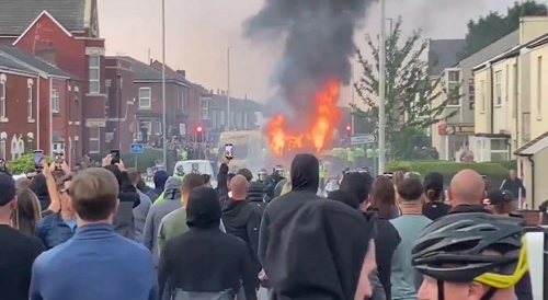 Cop car burned during riots in Southport after a terrorist stabbed children, killing 3