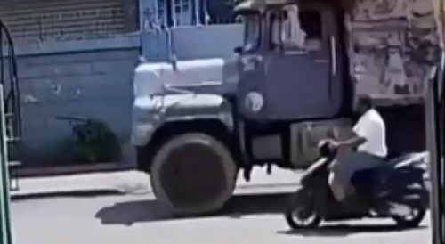 Motorcyclist Falls Head First Under The Truck Wheel