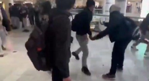 A group of young thugs beating a guy at the mall