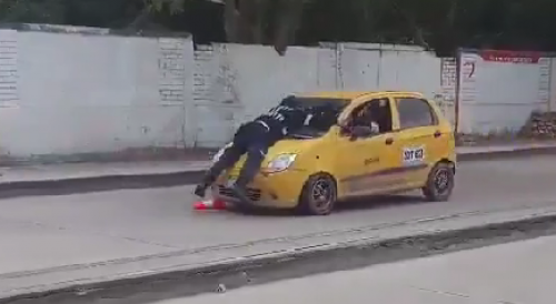 To avoid a fine, taxi driver drove off with a traffic officer on the hood in Colombia