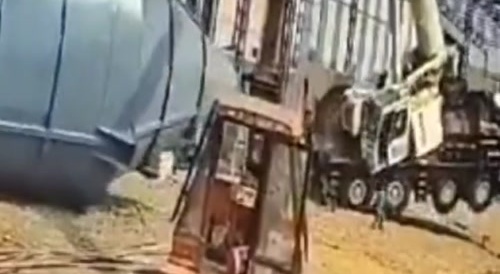 Worker operating inside a small crane cab gets smashed after a falling crane boom fell on it. India, 30 December 2024