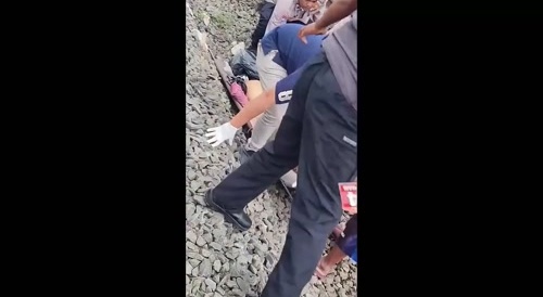 INDIA: pieces of a corpse are picked up from the tracks