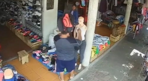 Thief steals a handbag from a mannequin.