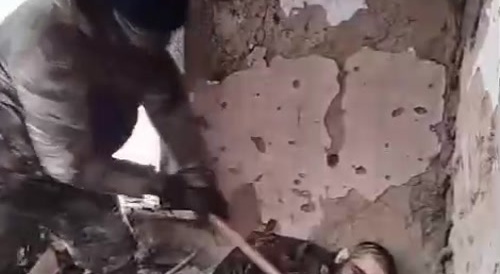 Russian soldier hammers dead Ukrainian soldier's head