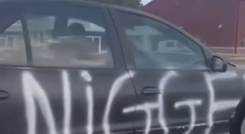 Car driving with n-word spray painted on it
