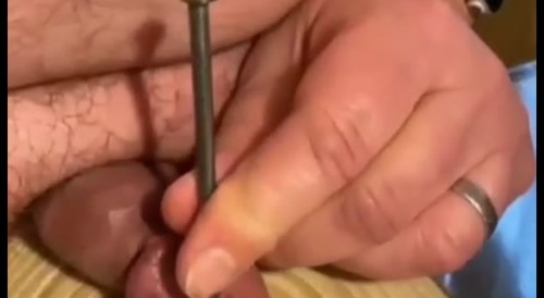 A man nails his penis' acorn down with a long thick nail... !
