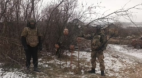archival footage of PMC wagner posing with heads on pikes
