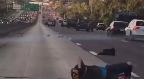 Motorbiker lies on the ground with leg screwed up...