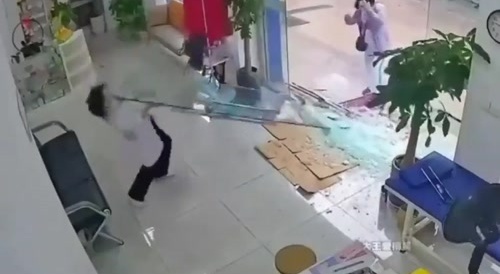 Woman shatters the glass doors entering a store...